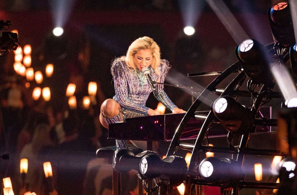 Im Glitzer-Body sitzt und singt Lady Gaga in der Halbzeitshow beim Super Bowl in Houston an ihrem Flügel. Foto: Getty Abo