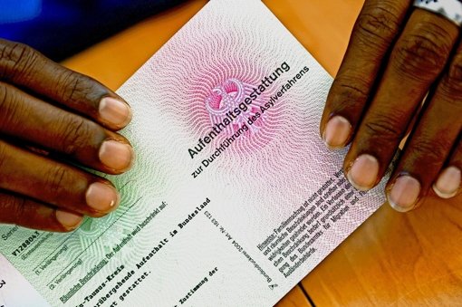 Die Anträge von Asylbewerbern sollen zügig bearbeitet werden, fordern fünf Bürgermeister in einem Brief. Ein Flüchtling aus Somalia zeigt seine „Aufenthaltsgestattung“. Foto: dpa