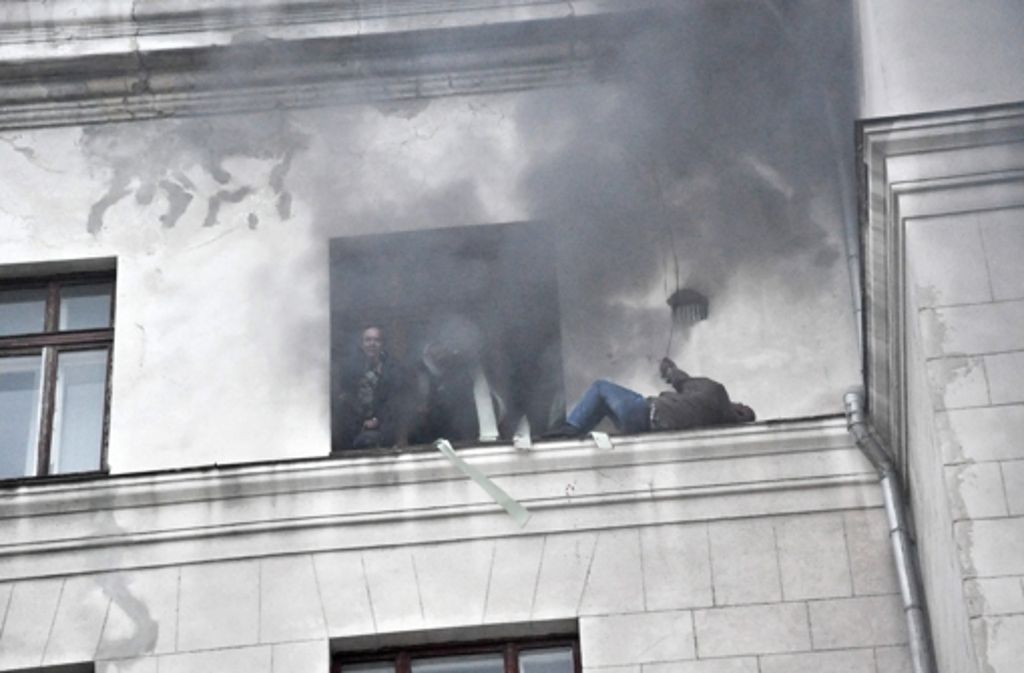 Menschen versuchen aus dem brennenden Gewerkschaftshaus in Odessa herauszukommen.