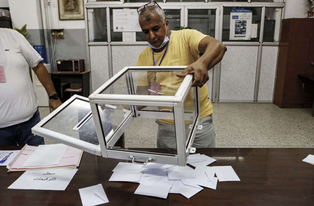 Ein Wahlhelfer in Algeriens Hauptstadt Algier leert eine Box mit Stimmzetteln, nachdem das Wahllokal geschlossen wurde. Foto: dpa/Farouk Batiche