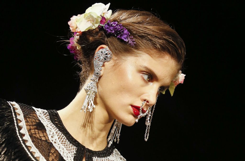 Die opulenten Looks des Designers werden durch Blumenkränze im Haar und große funkelnde Ohrringe ergänzt.