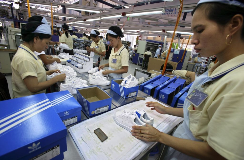 Archivfoto: Arbeiterinnen verpacken Sportschuhe in einer Adidas-Produktionsstätte in Vietnam. Der Sportartikelhersteller will die Produktion wieder ein Stück weit zurück vor die Haustür holen. Foto: dpa