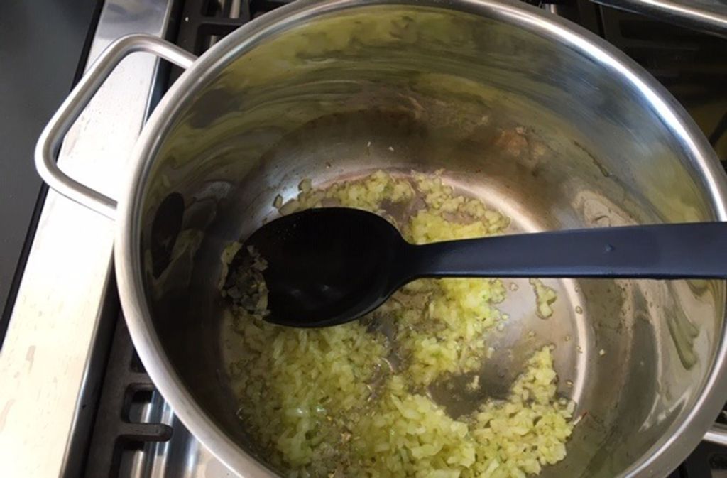 Für das Risotto erst die Zwiebel anschwitzen, dann den Reis dazu geben bis er glasig ist.