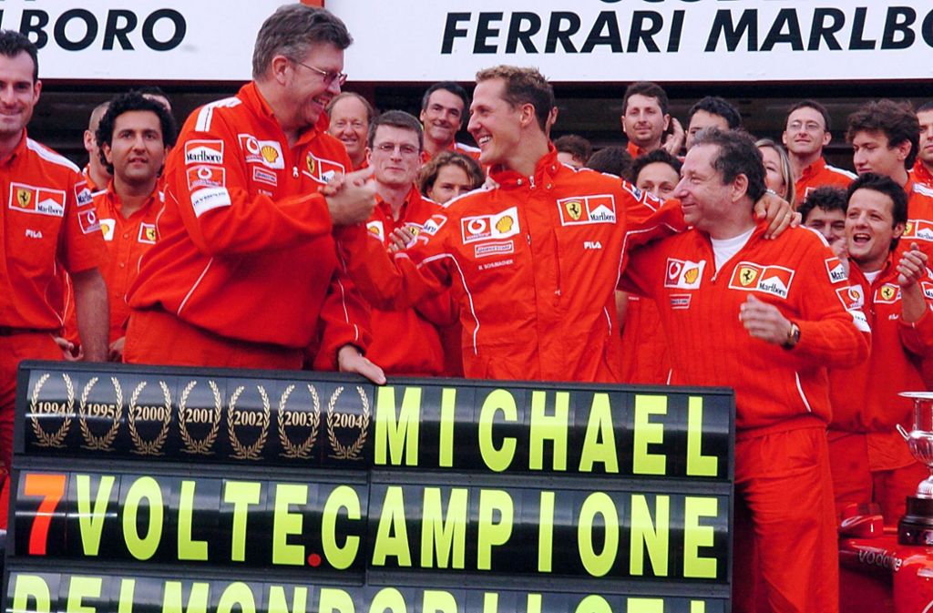 Diesen siebten Titel feiert Schumi mit der roten Mannschaft und mit Ross Brawn (links neben Schumacher), dem damaligen Ferrari-Superhirn.