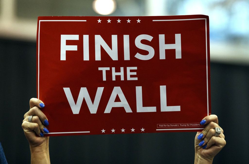 Ein Anhänger von US-Präsident Trump hält während einer Wahlkampfkundgebung in Cleveland im IX Center ein Schild mit der Aufschrift «Finish the Wall».