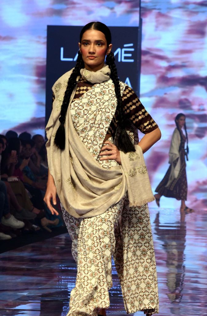 wie zum Beispiel den Sari, die traditionelle indische Tracht der Frauen, an den dieses hellbeige-gemusterte Kleid mit dem Wickelrock und dem übergeworfenen Schulterstoff erinnert.