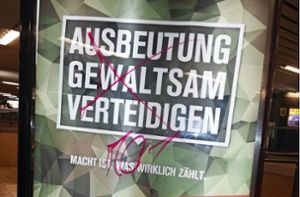 Aktivisten hängen militärkritische Plakate auf