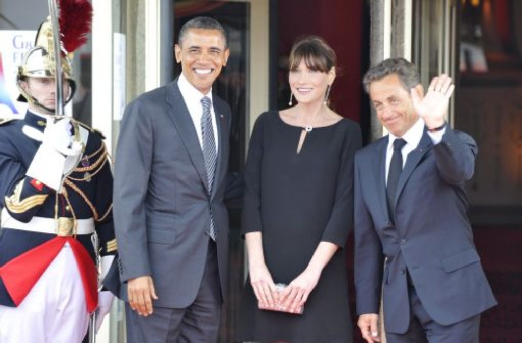 Carla Bruni (Mitte) mit ihrem Ehemann, dem früheren französischen Präsidenten Nicolas Sarkozy (rechts) und Barack Obama (links), dem Präsidenten der USA.