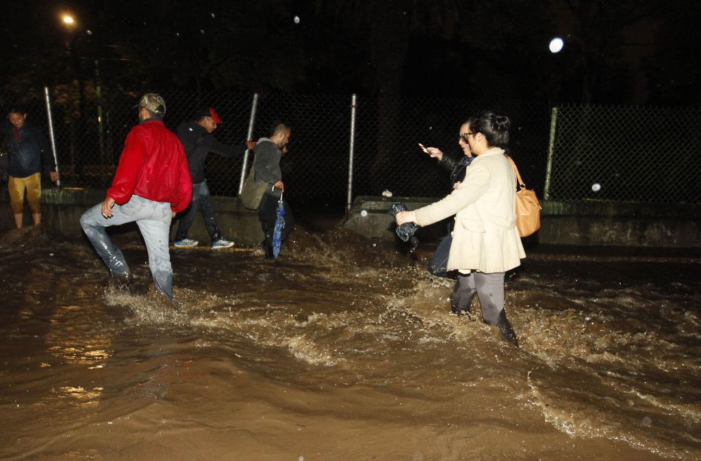 Anwohner waten am 6. September in Mexiko-Stadt durch das Wasser einer überfluteten Straße.