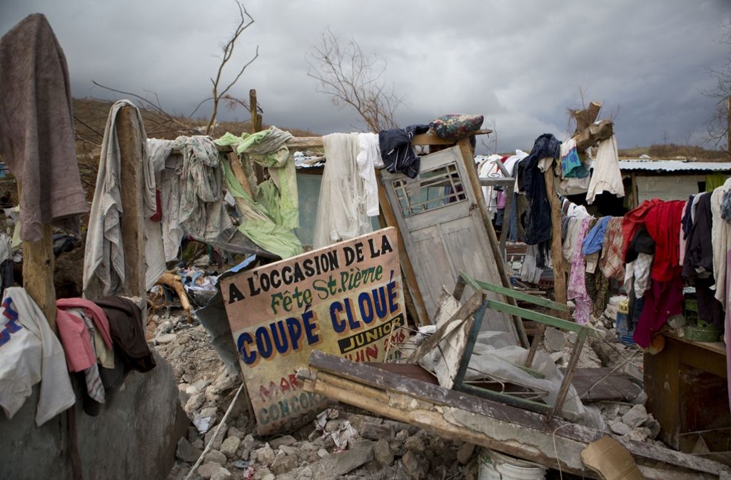 Ein Schild kündigt auf Französisch ein Konzert an – drumherum versuchen die Haitianer ihre nasse Wäsche zu trocknen.
