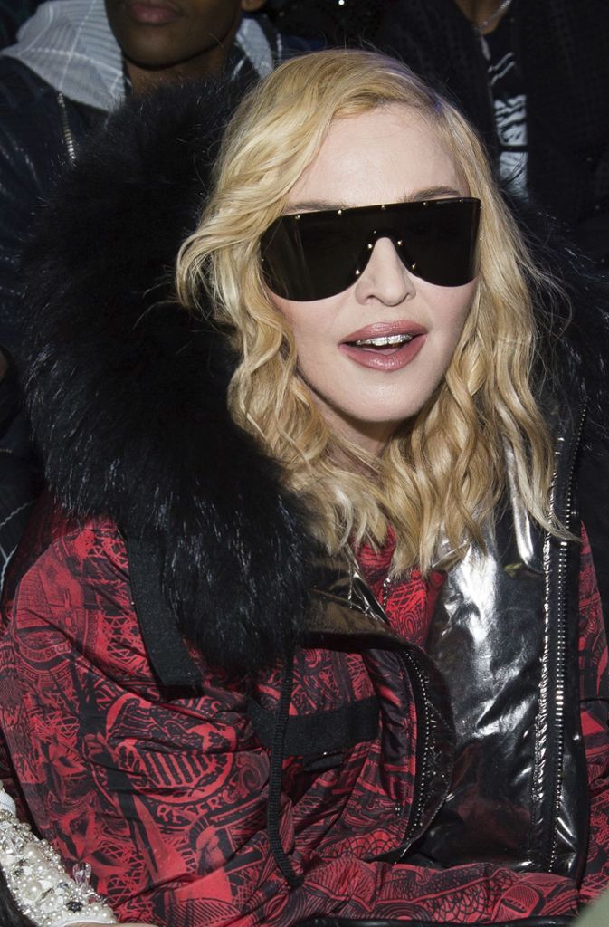 Sängerin Madonna erscheint warm eingepackt und mit großer Sonnenbrille.