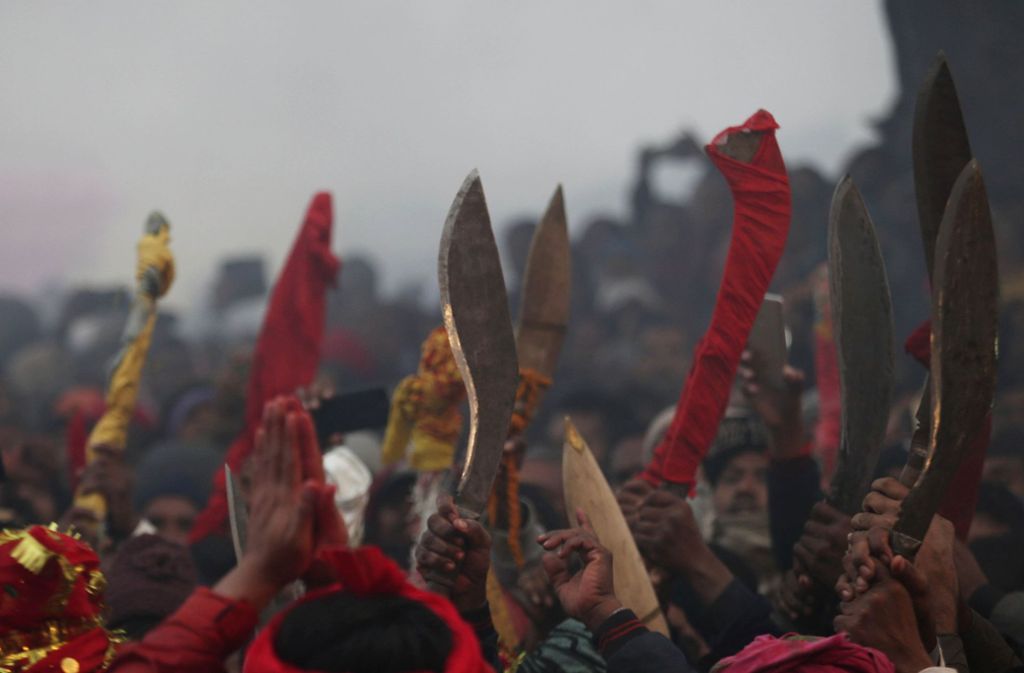 Männer mit erhobenen Klingen versammeln sich zum zweitägigen Opferfest für die hinduistische Göttin der Macht Gadhimai.