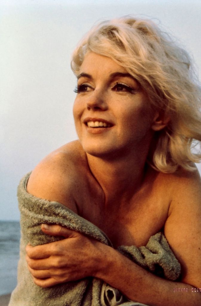 Die Reproduktion zeigt Marilyn Monroe, aufgenommen von Fotograf George Barris 1962 am Strand in der Sonne.