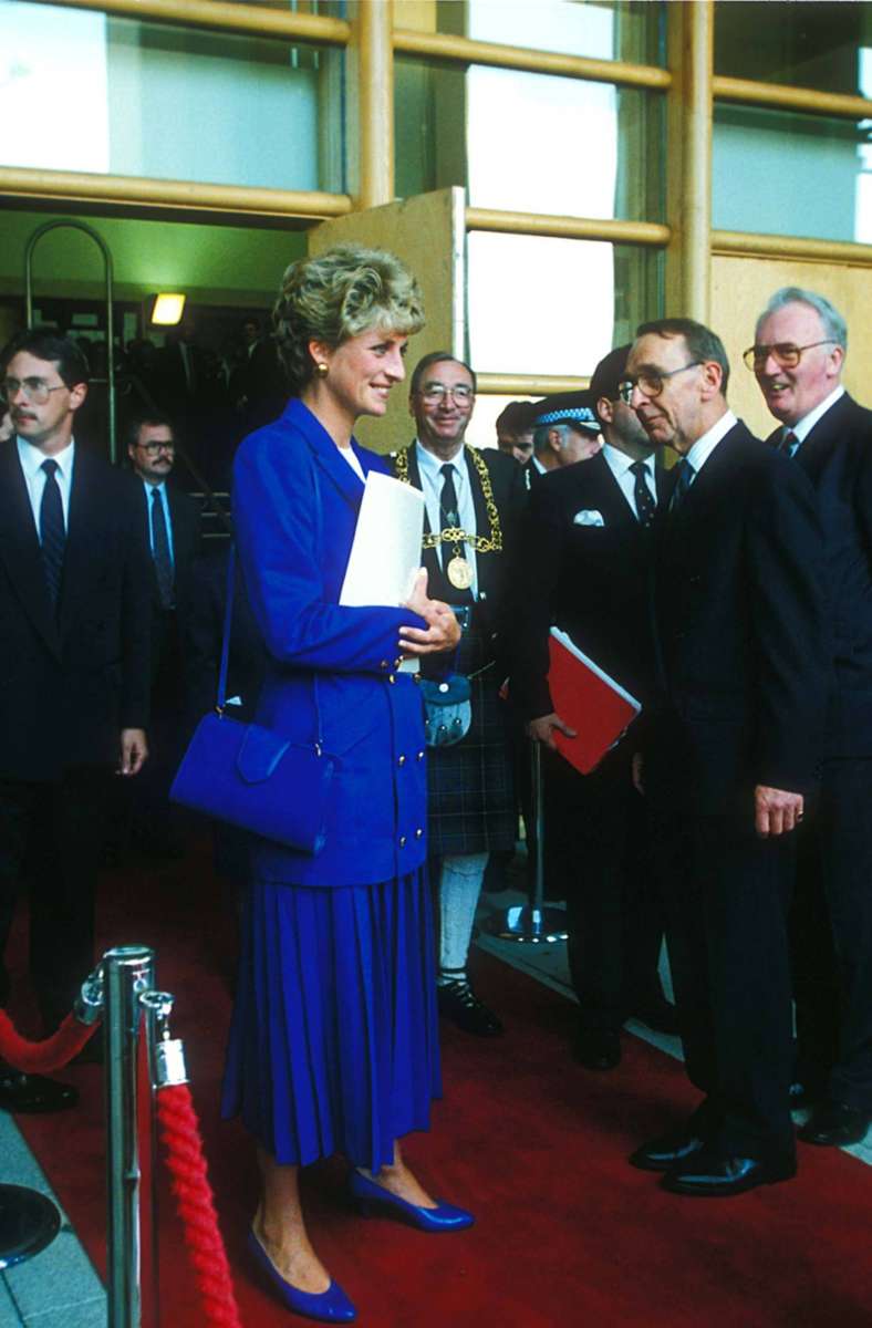 1992: Longblazer mit Goldknöpfen, Faltenrock – sogar Prinzessin Dianas Handtasche und die Pumps sind auf den Look in Royalblau abgestimmt.