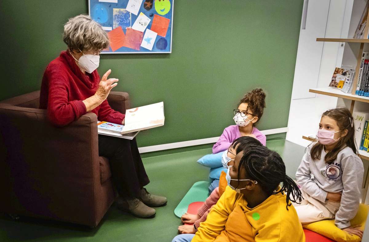 Eine Vorlesepatin liest vor. Die Kinder hören gespannt zu. Foto: Lichtgut/Achim Zweygarth