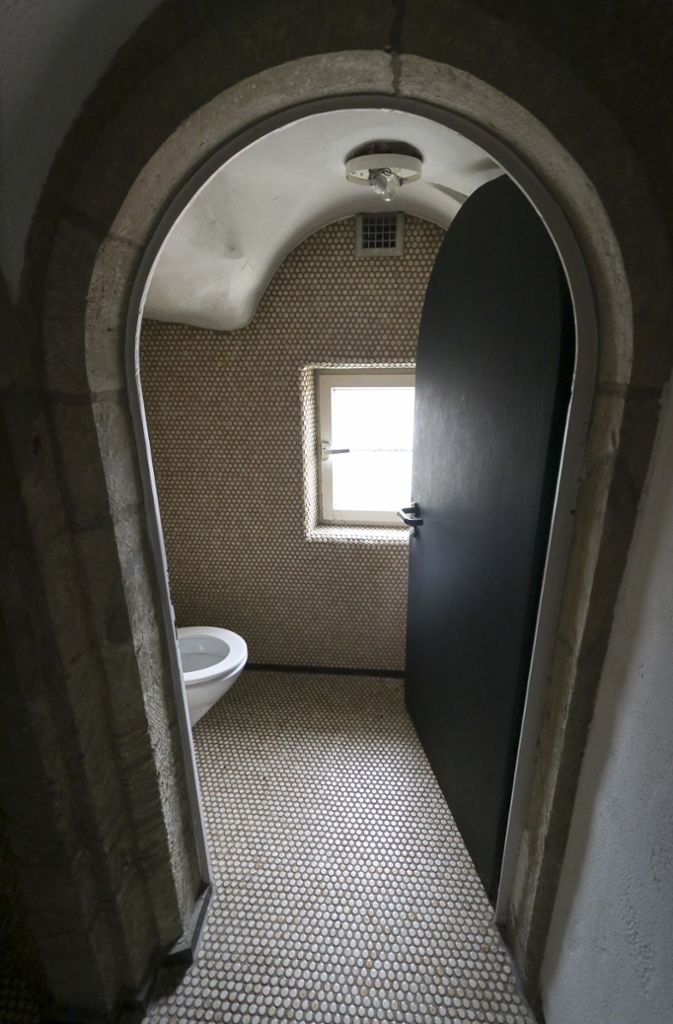 Auf Denkmalschutz wurde damals wenig geachtet: Hier führt ein romanischer Torbogen direkt in einen gefließten Toilettenraum.