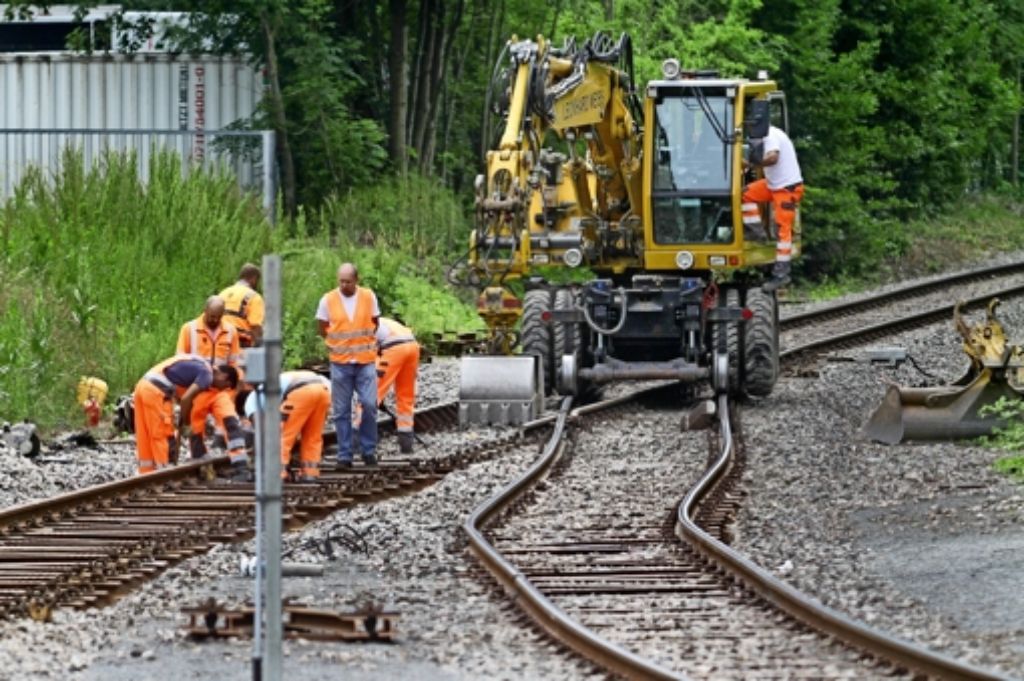 Arbeiter begutachten die verbogenen Gleise hinter einer Weiche am Schwieberdinger Bahnhof Foto: factum/Granville