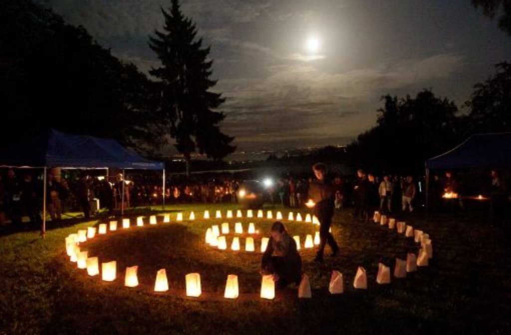 Jugendliche stellen am Sonntag in Überlingen-Brachenreuthe (Bodenseekreis) im Rahmen einer Gedenkfeier Kerzen für die Opfer des Flugzeugabsturzes vor zehn Jahren in Form einer Spirale auf. Foto: dpa