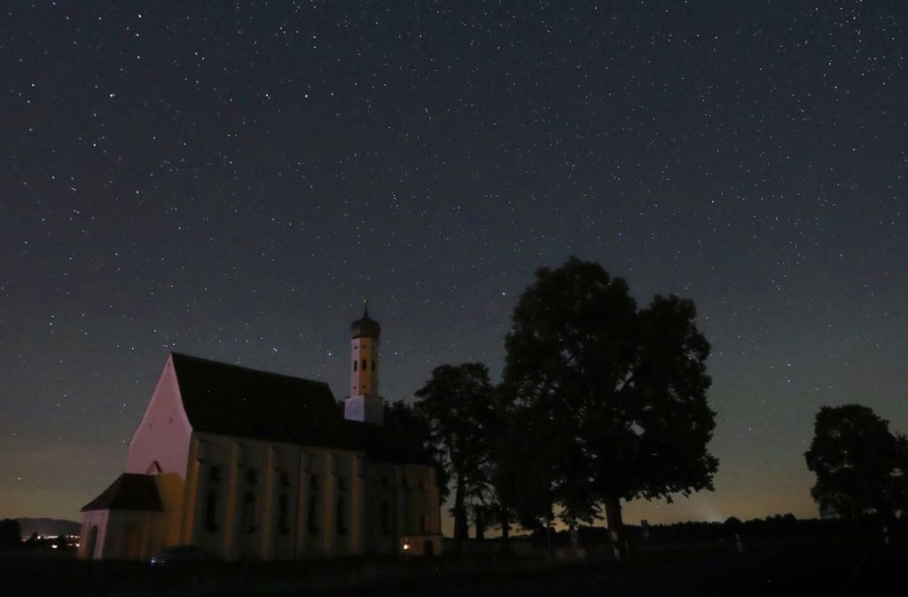 Eine Sternschnuppe über der Wallfahrtskirche Sankt Coloman bei Füssen im Allgäu.