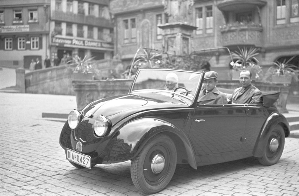 Der Maschinenbauer Ferdinand Piëch startete seine Karriere 1963 bei der Porsche KG in Stuttgart-Zuffenhausen. Sein Onkel Ferdinand („Ferry“) Porsche junior hatte den Autohersteller nach 1945 aus dem früheren Volkswagen-Entwicklungswerk aufgebaut. Das Werksfoto von 1936 zeigt Ferry Porsche am Steuer des zweiten Volkswagen-Prototypen (V2), fotografiert auf dem Marktplatz in Tübingen. Neben ihm seine Frau Dorothea. Auf dem Rücksitz Hellmuth Zarges, ein Freund der Familie Porsche. Ferdinand Piëch, der Autobauen zeitlebens als sein Hobby bezeichnete, arbeitete sich schnell nach oben. Er übernahm 1966 die Leitung der Motoren-Versuchsabteilung und Anfang 1968 den Bereich Entwicklung. Piëch wurde 1971 technischer Geschäftsführer der KG. Die Familien Porsche und Piëch, denen Porsche gehört, wandelten die KG 1972 in die Dr.-Ing. h. c. F. Porsche AG um. Alle Familienmitglieder zogen sich aus dem operativen Geschäft zurück. Externe Manager führten das Unternehmen im Tagesgeschäft – im Sinne der beiden Familien.