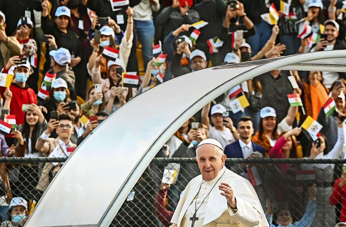Während seiner Irakreise 2021 winkt Franziskus aus dem Papamobil den Menschen zu. Foto: dpa/STR