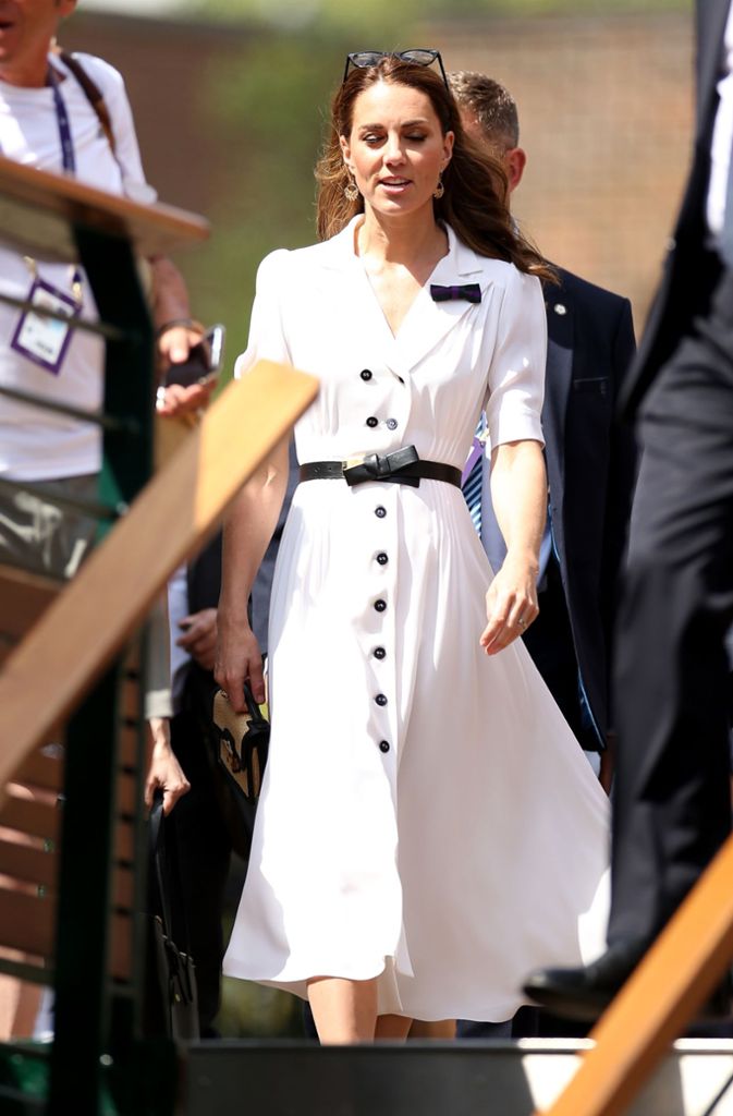 2019: Herzogin Kate trägt ein durchgeknöpftes Seidenkleid (Suzannah) in angesagter Midi-Länge. Dazu kombiniert die 37-Jährige einen schmalen schwarzen Gürtel, der sich in der niedlichen Schleife am Revers widerspiegelt.