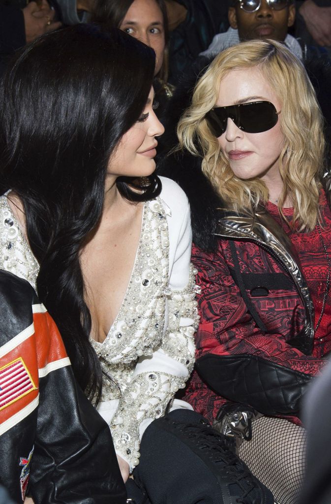 Der amerikanische Reality-Star nimmt neben Pop-Queen Madonna (rechts) Platz.