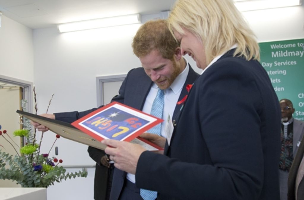 Prinz Harry betrachtet ein eingerahmtes Bild vom Besuch seiner Mutter in dem Krankenhaus, das er jetzt selbst besucht.