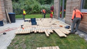 Auszubildende bauen Terrasse mit Holz aus dem Stadtwald
