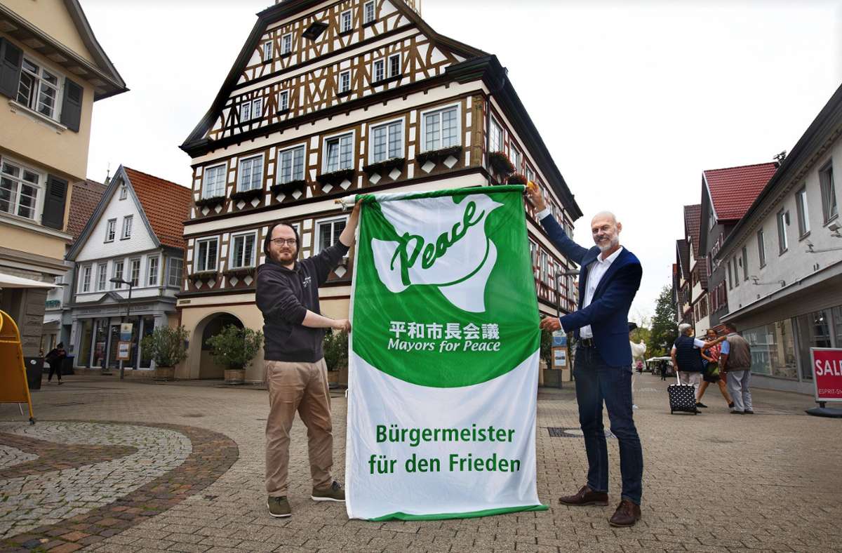 Der Kirchheimer Oberbürgermeister Pascal Bader (rechts) und der Rathaussprecher  Robert Berndt mit der Friedensflagge. Foto: /Horst Rudel