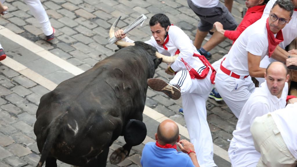 Stierhatz in Pamplona: Läufer von Stier an Achselhöhle aufgespießt