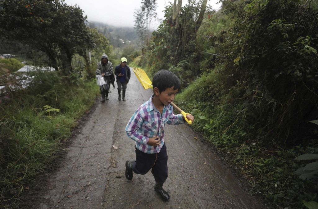 Dieses Bild zeigt den kolumbianischen Jungen Jeimmer Alejandro Riveros. Er ist neun Jahre alt, hinter ihm sind seine Mutter Nubia Rocio Gaona, 37, und sein Bruder David, 14, zu sehen. Sie sind unterwegs zu ihrer kleinen Farm. Während der Corona-Pandemie hat die Familie Medienberichten zufolge mit sinkenden Lebensmittelpreisen zu kämpfen. Deshalb haben die drei einen Youtube-Kanal gestartet, auf dem sie Zuschauern beibringen, wie man Gemüse anbaut.