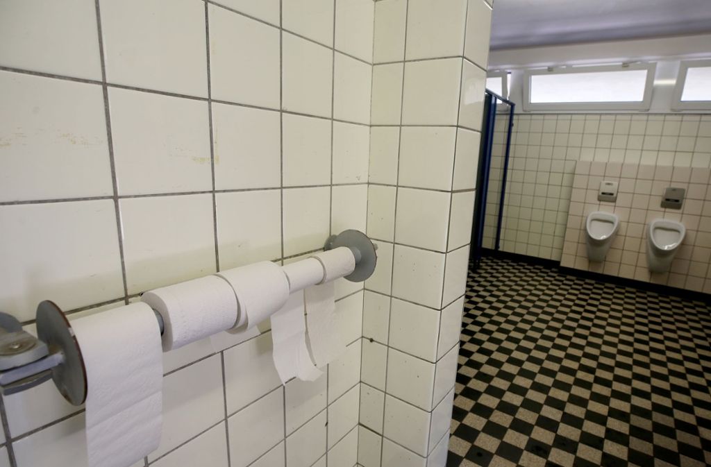 Mit einem Hängeschloss gesicherte Toilettenpapierrollen hängen in einer noch nicht renovierten Toilette einer Grundschule im nordrhein-westfälischen Duisburg. Foto: Roland Weihrauch/dpa