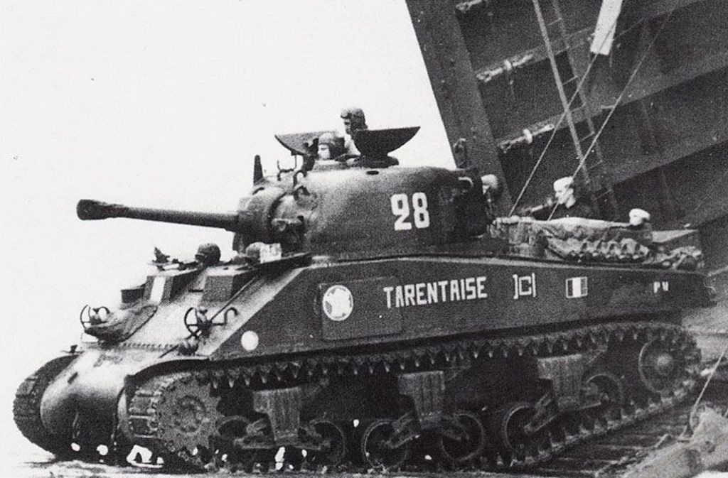 Ein Sherman-Panzer verlässt ein US-Landungsboot an der normannischen Küste.