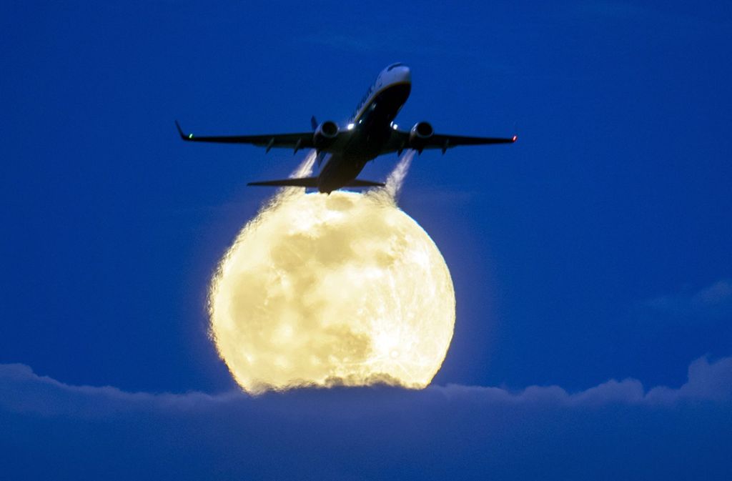 Der Mond leuchtet über dem Frankfurter Flughafen.