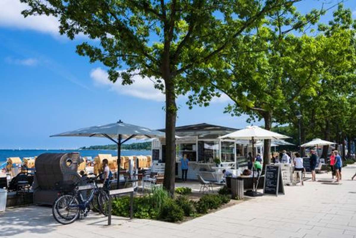 Ein Bistro an der Strandpromenade der Kieler Förde. Wer bekommt da nicht Lust sein Fahrrad für eine Pause zu parken und sich einen kühlen Drink zu gönnen? Foto: Shutterstock/penefoto