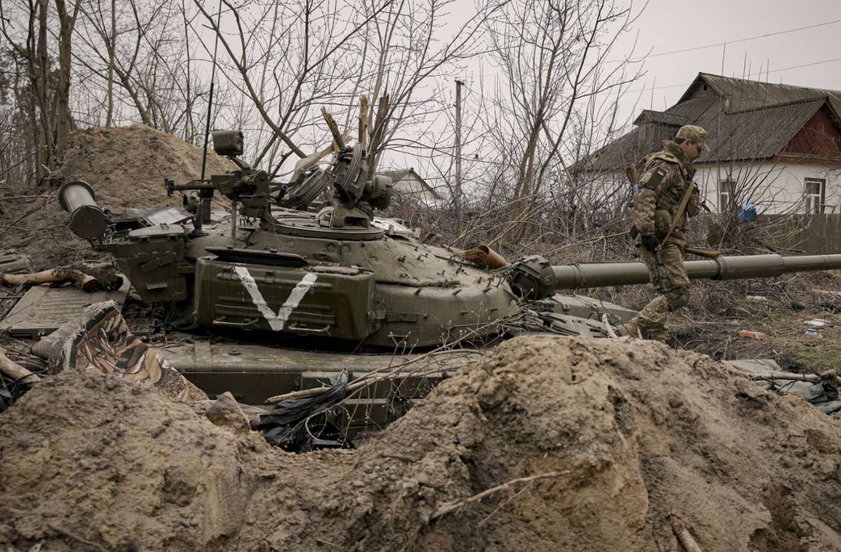 Ein ukrainischer Soldat geht an einem verlassenen Panzer der russischen Armee in der Stadt Andrijiwka  vorbei. Foto: AP/dpa/Vadim Ghirda