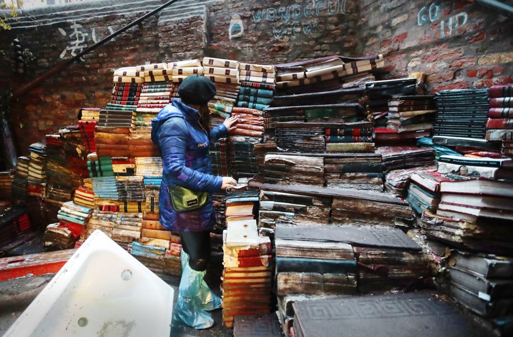Eine junge Frau überprüft den Zustand von Büchern aus der renommierten Buchhandlung „Acqua Alta“ (Hochwasser).
