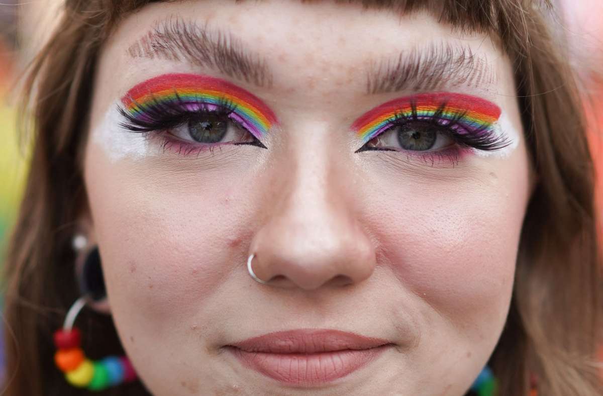 Die Augen von Marie sind bei der Parade des Christopher Street Day (CSD) in Regenbogenfarben geschminkt.