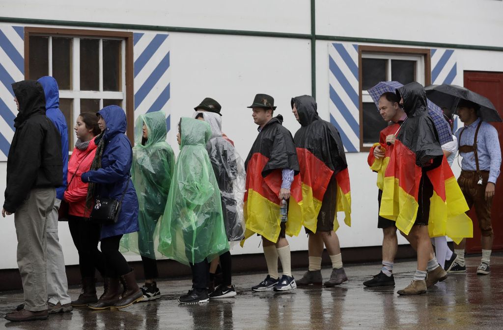 Zehntausende Menschen kamen bereits seit den frühen Morgenstunden trotz Regens auf die Theresienwiese. Dort waren durchsichtige Capes und Regenschirme ein beliebtes Utensil für die sonst meist in bunte Tracht gehüllten Besucher.