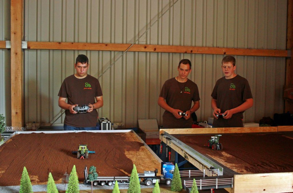 In der Maschinenhalle des Hofes präsentieren Modellbauer ihre selbst umgebauten Nutzfahrzeuge. Getrockneter Kaffeesatz dient dabei als Feldmaterial.