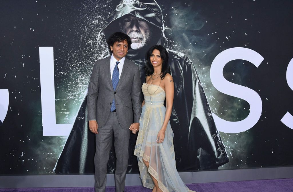 Regisseur M. Night Shyamalan lief mit seiner Frau über den lilafarbenen Teppich.