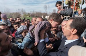 Dieses von der syrischen Regierung zur Verfügung gestellte Bild zeigt Baschar al-Assad (rechts), der Präsident von Syrien, der bei einem Besuch der syrischen Regierungstruppen in der umkämpften Region Ost-Ghuta einen Jungen hält. Foto: dpa/Syrian Presidency