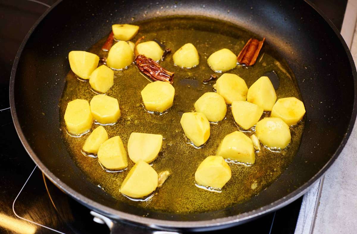 1 Prise Salz und TL Kurkuma darüber streuen. Kartoffeln ca. 4 Minuten braten.
