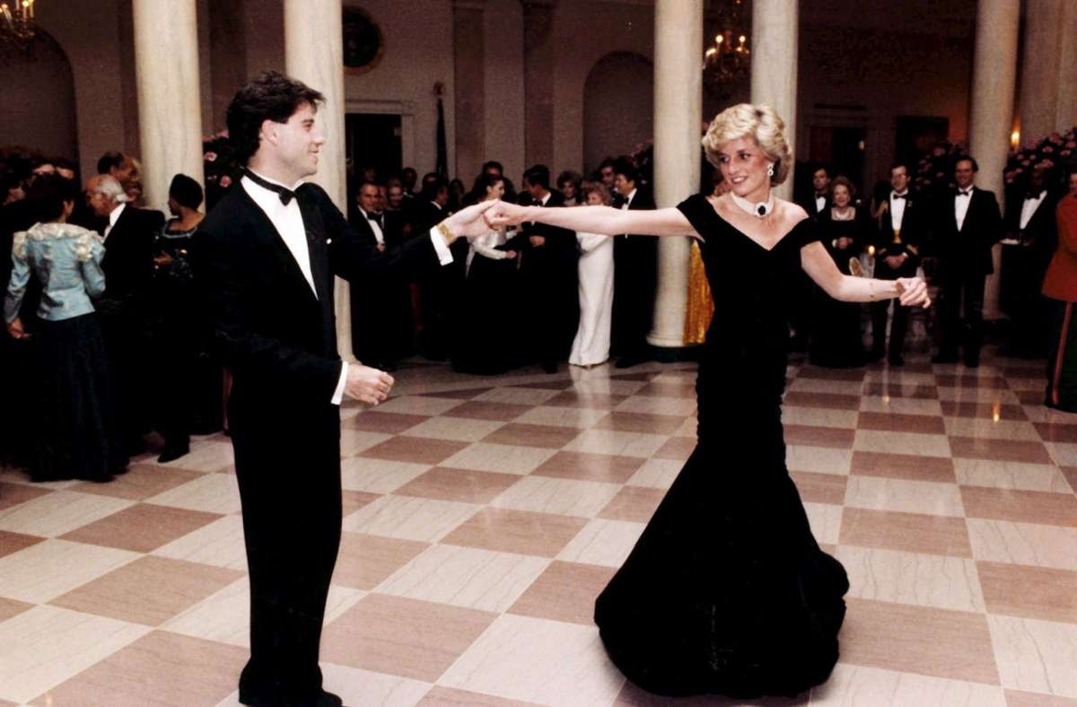 1985: Wer erinnert sich nicht an dieses Kleid? Das tintenblaue Samtkleid von Victor Edelstein, in dem Diana bei einem Staatsbankett im Weißen Haus mit John Travolta auf dem Tanzparkett herumwirbelte, ist Kult.