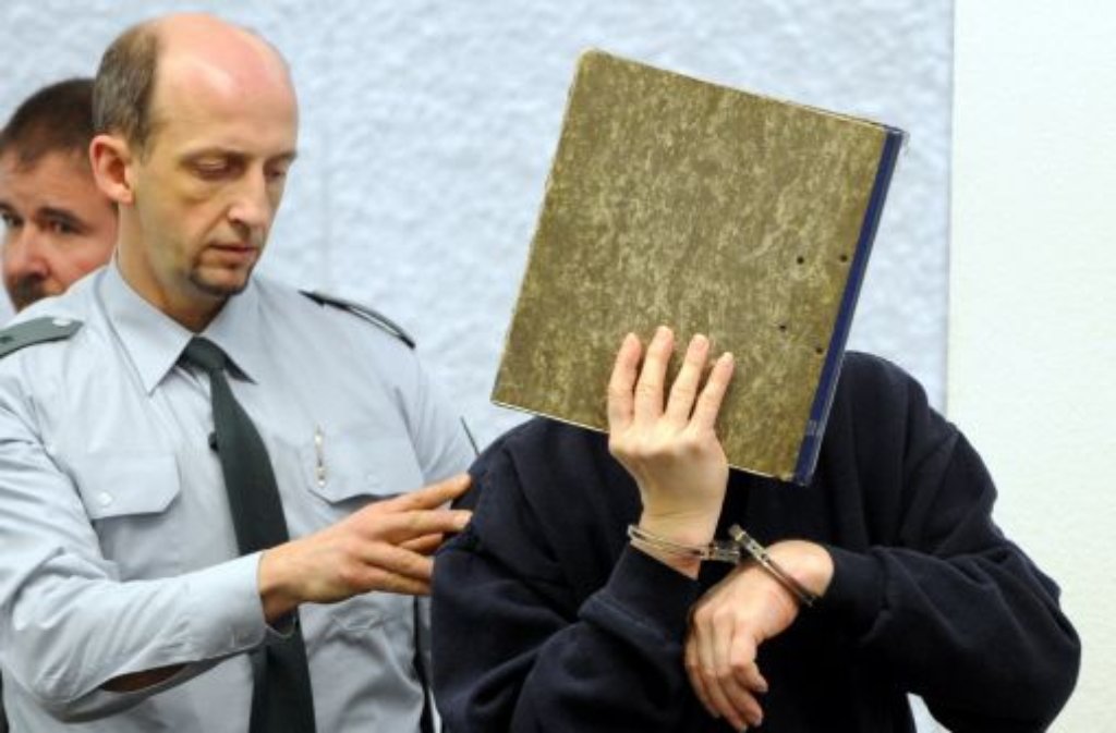 Der Angeklagte im Mordfall Tobias wird am Donnerstag bei Prozessbeginn im Landgericht in Stuttgart von einem Justizbeamten in den Gerichtssaal geführt. Foto: dpa