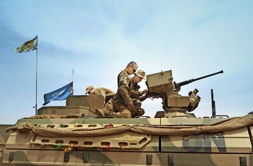 Fertigmachen zur Patrouille für diese bayerischen Soldaten – die blaue Flagge macht deutlich, dass die deutschen Soldaten im Auftrag der Vereinten Nationen unterwegs sind. Foto: Schiermeyer