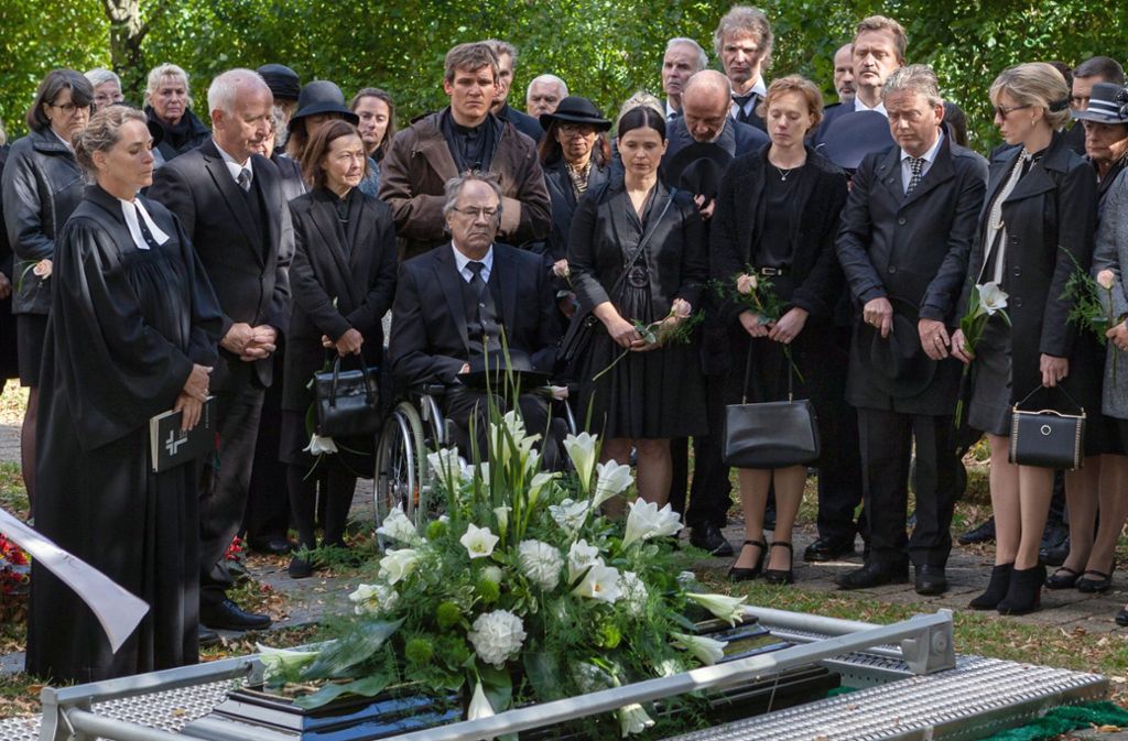 Lisa (Anna Fischer) und ihr Vater Alfons (Hartmut Volle, im Rollstuhl) wohnen der Beerdigung von Ilse Wertbacher bei.