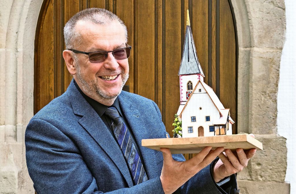 Pfarrer Holger Küstermann hat die Kirche nicht in der Hand – er trägt  das Modell der  Mauritiuskirche auf Händen. Auch  dort sollen sich Menschen treffen. Foto: factum/Weise