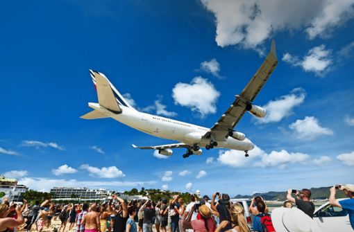 Nur  etwa 20 bis 25 Meter über den Köpfen der Strandbesucher landen die Urlaubsflieger auf dem  Princess Juliana International Airport auf der Insel Sint Maarten. Foto: imago images/Westend61/Martin Moxter